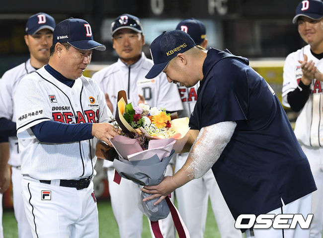 [OSEN=잠실, 곽영래 기자]두산은 20일 서울 잠실구장에서 열린 KIA 타이거즈와의 홈경기에서 6-2로 승리하고 3연승을 내달렸다. KIA는 2연패 부진에 빠졌다.7년 연속 10승을 거둔 두산 유희관이 김태형 감독으로부터 꽃다발을 건네받고 있다. / youngrae@osen.co.kr