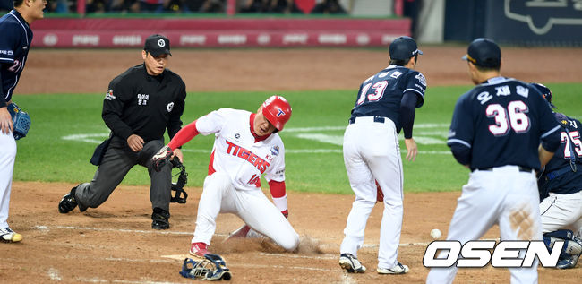 [OSEN=광주, 최규한 기자]8회말 1사 1, 3루 상황 KIA 나지완의 3루수 땅볼 때 런다운에 걸린 김주찬이 홈을 파고 들어 세이프되고 있다. /dreamer@osen.co.kr