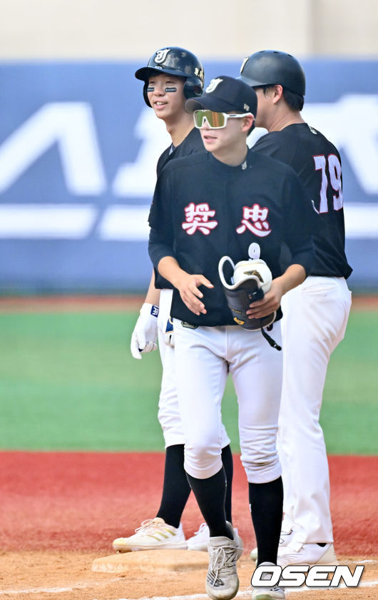 [OSEN=목동, 민경훈 기자] 19일 서울 목동야구장에서 제78회 청룡기 전국고교야구선수권대회 겸 주말리그 왕중왕전 2회전 군산상일고와 장충고의 경기 진행됐다.5회말 무사 주자 1루 번트 안타에 성공한 장충고 황준서가 1루에서 축하를 받고 있다. 2023.07.19 / rumi@osen.co.kr