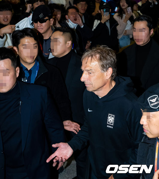 [OSEN=인천공항, 민경훈 기자] 4강에서 요르단에 패하며 2023 카타르 아시안컵 여정을 마무리한 대한민국 축구대표팀이 8일 오후 인천국제공항을 통해 입국했다.클린스만 감독이 입국장을 통과할때 축구 팬들이 욕을 하자 클린스만 감독이 의아하다는 제스처를 취하고 있다. 2024.02.08 / rumi@osen.co.kr