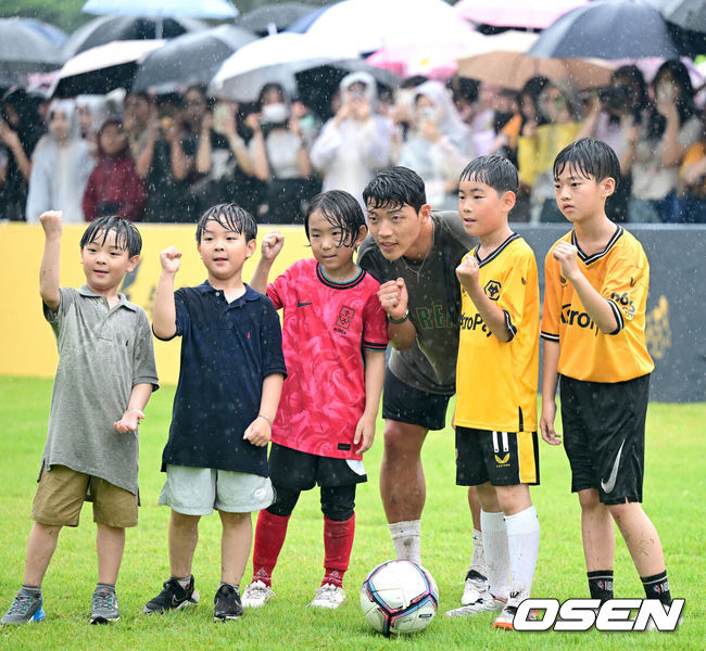 [OSEN=부천, 최규한 기자] 22일 오후 경기도 부천시청 잔디광장에서 ‘2024 황희찬 풋볼 페스티벌’이 열렸다.이번 행사는 황희찬의 축구용품 전시회, 풋볼 페스티벌, 팬 미팅, 멘토링 시간 등으로 구성된다. 황희찬은 팬 미팅 수익금 전액을 기부할 예정이다. 황희찬(28, 울버햄튼)이 어린이들과 함께 풋살 경기를 펼친 뒤 기념사진을 찍고 있다. 2024.06.22 / dreamer@osen.co.kr