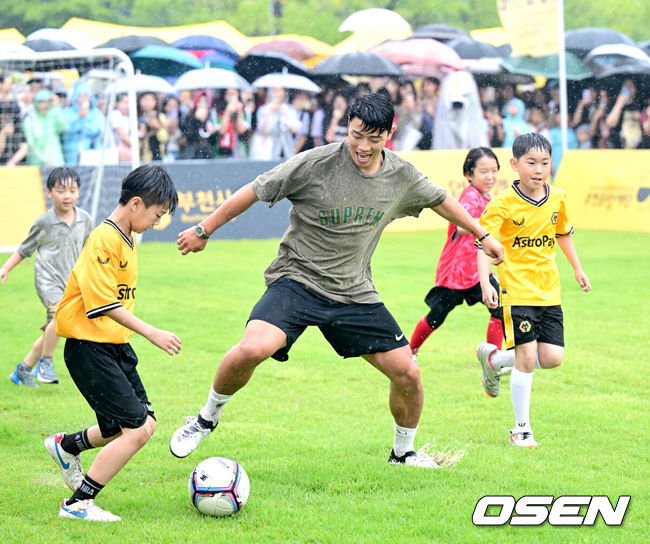 [OSEN=부천, 최규한 기자] 22일 오후 경기도 부천시청 잔디광장에서 ‘2024 황희찬 풋볼 페스티벌’이 열렸다.이번 행사는 황희찬의 축구용품 전시회, 풋볼 페스티벌, 팬 미팅, 멘토링 시간 등으로 구성된다. 황희찬은 팬 미팅 수익금 전액을 기부할 예정이다. 황희찬(28, 울버햄튼)이 어린이들과 함께 풋살 경기를 펼치고 있다. 2024.06.22 / dreamer@osen.co.kr