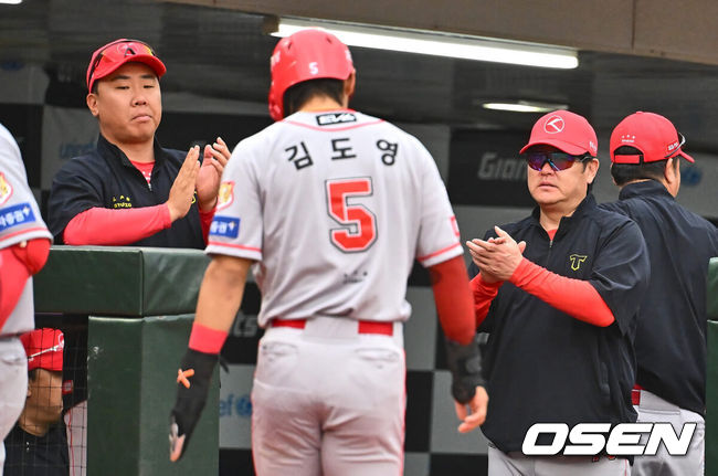 [OSEN=부산, 이석우 기자] 25일 부산 사직야구장에서 2024 신한 SOL 뱅크 KBO 리그 롯데 자이언츠와 KIA 타이거즈의 경기가 열렸다. 홈팀 롯데는 나균안이 선발 출전하고 KIA는 네일이 선발 출전했다.KIA 타이거즈 김도영이 1회초 무사 2루 최형우의 1타점 우중간 안타 때 득점을 올리고 이범호 감독과 진갑용 코치의 축하를 받고 있다. 2024.06.25 / foto0307@osen.co.kr