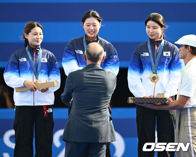 [OSEN=파리(프랑스), 최규한 기자] 한국 여자 양궁이 올림픽 10연패 대기록을 쐈다.<br /><br />임시현(한국체대), 남수현(순천시청), 전훈영(인천시청)으로 구성된 한국 양궁 대표팀은 프랑스 파리 앵발리드에서 열린 ‘2024 파리올림픽’ 양궁 여자 리커브 단체전 결승서 중국(안치쉬안, 리지아만, 양사오레이) 상대로 5-4(56-53, 55-54, 51-54, 53-55, 29-27)로 승리하면서 대회 10연패를 달성했다.<br /><br />금메달을 거머쥔 한국 임시현-남수현-전훈영이 시상자로 나선 정의선 현대차 회장에게 기념품을 받고 있다. 2024.07.29 / dreamer@osen.co.kr<br />