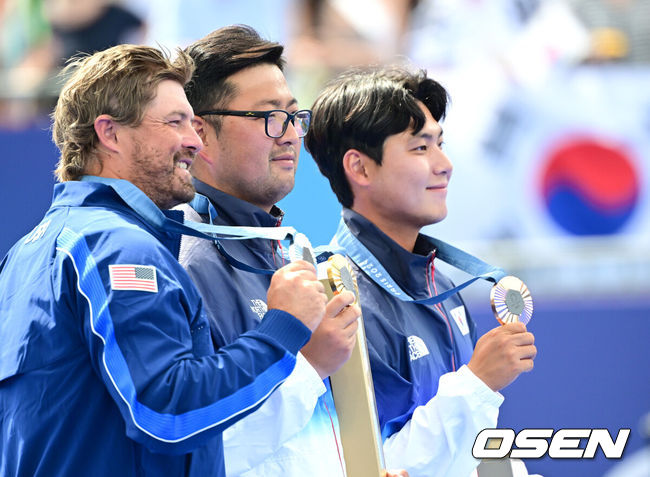 [OSEN=파리(프랑스), 최규한 기자] 4일(한국시간) 프랑스 파리 레쟁발리드에서 ‘2024 파리올림픽’ 양궁 남자 리커브 개인 금메달결정전 한국 김우진과 미국 브래들리 엘리슨의 경기가 열렸다.김우진은 역대 올림픽에서 5번째 금메달을 목에 건 최초의 한국 선수가 됐다. 여기에 파리 올림픽 3관왕을 이뤄냈다. 더불어 김우진의 금메달로 이번 한국 양국 대표팀은 양궁 전종목에서 금메달을 모두 차지하는 대기록을 작성했다.금메달 한국 김우진, 은메달 미국 브래디 엘리슨, 동메달 한국 이우석이 포즈를 취하고 있다. 2024.08.04 / dreamer@osen.co.kr