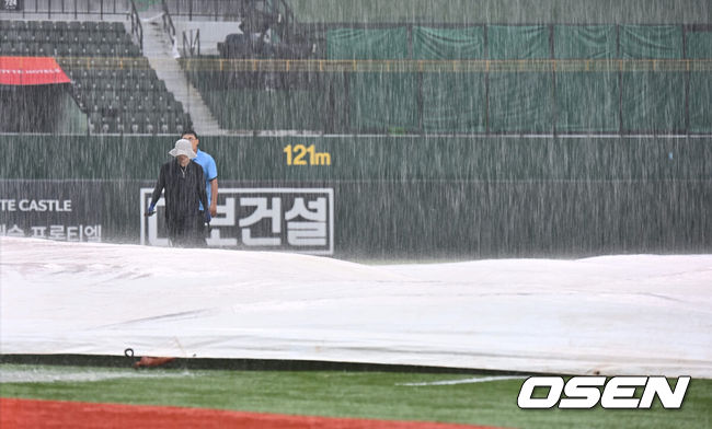 [OSEN=부산, 이석우 기자] 6일 부산 사직야구장에서 2024 신한 SOL 뱅크 KBO 리그 롯데 자이언츠와 NC 다이노스의 경기가 열린다. 홈팀 롯데는 윌커슨이 선발 출전하고 NC는 신민혁이 선발 출전한다.갑자기 내린 폭우로 관계자들이 방수포를 덮은 후 살펴보고 있다. 2024.08.06 / foto0307@osen.co.kr