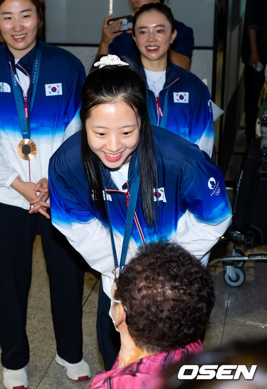 [OSEN=인천공항, 민경훈 기자] 2024 파리 올림픽 한국 탁구 대표팀이 12일 오후 인천국제공항을 통해 귀국했다. 대한민국 탁구 대표팀은 신유빈-임종훈이 출격한 혼합복식과 신유빈-전지희-이은혜가 나선 여자 단체전에서 각각 동메달 1개씩을 획득하며 12년 만에 한국 탁구에 메달을 안겼다. 탁구대표팀 신유빈이 입국한 후 축하를 받으며 미소짓고 있다. 2024.08.12 /rumi@osen.co.kr