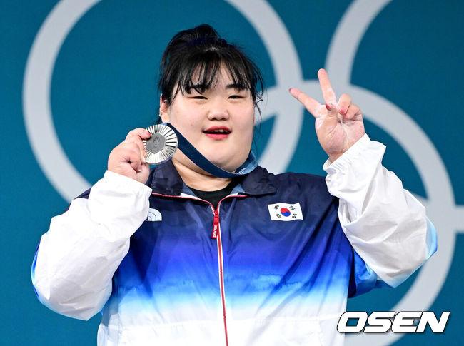 [OSEN=파리(프랑스), 최규한 기자] 11일(한국시간) 프랑스 팔이 사우스 파리 아레나6에서 ‘2024 파리올림픽’ 역도 여자 81㎏ 초과급 결선이 열렸다.박혜정은 인상 131kg로 한국신기록을 작성했다. 이어진 용상에서 168kg를 들어 합계 299kg로 한국신기록을 작성하며 파리올림픽 은메달을 확정지었다.박혜정이 시상대에서 은메달과 함께 포즈를 취하고 있다. 2024.08.11 / dreamer@osen.co.kr