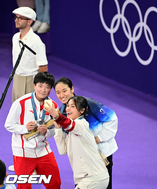 [OSEN=파리(프랑스), 최규한 기자] 5일(한국시간) '셔틀콕 여제' 안세영(22, 삼성생명)이 꿈에 그리던 올림픽 금메달을 목에 걸었다.<br /><br />세계 랭킹 1위 안세영은 5일 오후(이하 한국시간) 프랑스 파리 포르트 드 라샤펠 경기장에서 열린 2024 파리올림픽 배드민턴 여자 단식 결승전에서 랭킹 9위 허빙자오(중국)를 2-0으로 꺾고 금메달을 획득 했다.  <br /><br />금메달 한국 안세영(가운데)와 은메달 중국 허빙자오, 동메달 인도네시아 툰중이 시상대에서 기념촬영을 있다. 2024.08.05 / dreamer@osen.co.kr