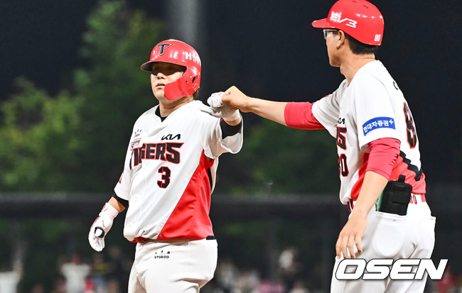 적시타를 터트린 김선빈이 1루 주루코치의 축하를 받고 있다./OSEN DB