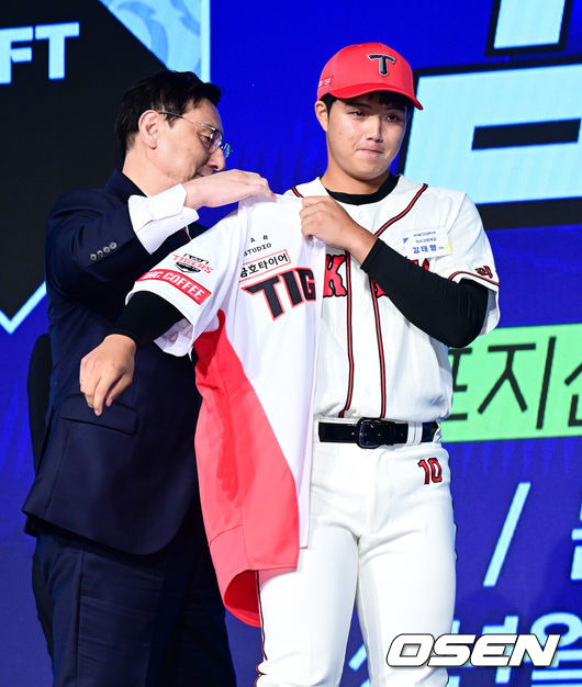 [OSEN=지형준 기자] 11일 오후 서울 잠실 롯데호텔 월드에서 2025 KBO 신인 드래프트가 열렸다.2025 KBO 신인 드래프트는 전면 드래프트 방식으로 진행된다. 지명은 1라운드부터 11라운드까지 이뤄지며, 2023년도 구단 순위의 역순인 키움-한화-삼성-롯데-KIA-두산-NC-SSG-KT-LG 순서로 실시된다.덕수고 김태형이 KIA에 1라운드 지명되며 심재학 단장이 유니폼을 전달하고 있다. 2024.09.11 / jpnews@osen.co.kr