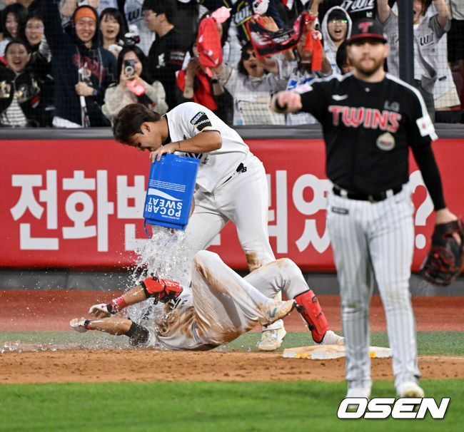 [OSEN=수원, 민경훈 기자] 9일 수원KT위즈파크에서 2024 신한 SOL뱅크 KBO 포스트시즌 준플레이오프 4차전 KT 위즈와 LG 트윈스의 경기가 진행됐다. 이 경기에서 KT는 LG에 연장 11회말 6-5 끝내기 승리를 거두며 승부를 준PO 5차전으로 끌고 갔다.연장 11회말 2사 만루 KT 심우준이 끝내기 안타를 친 후 강백호에게 끝내기 물세례를 받고 있다. 2024.10.09 /  rumi@osen.co.kr