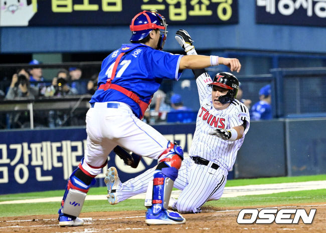 [OSEN=잠실, 최규한 기자] 17일 서울 잠실야구장에서 ‘2024 신한 SOL뱅크 KBO 포스트시즌’ 플레이오프 3차전 LG 트윈스와 삼성 라이온즈의 경기가 열렸다.LG는 임찬규, 삼성은 황동재를 3차전 선발 투수로 내세웠다.5회말 1사 1, 3루 상황 LG 홍창기의 선제 1타점 희생플라이 때  3루 주자 박동원이 홈으로 태그업 해 슬라이딩, 세이프되고 있다. 2024.10.17 / dreamer@osen.co.kr