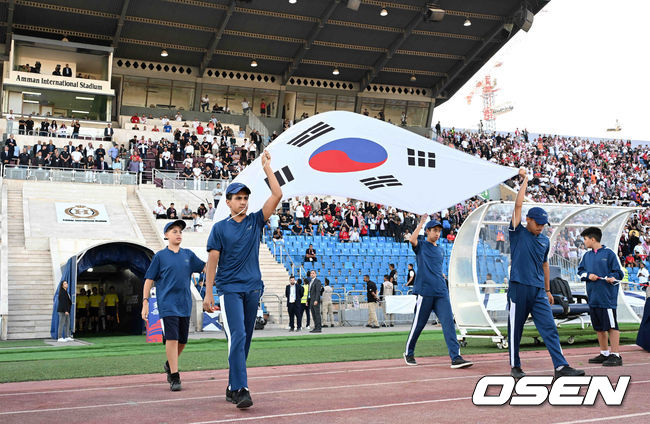 [OSEN=암만(요르단), 손용호 기자] 10일 오후(한국시간) 요르단 암만 국제경기장에서 2026 국제축구연맹(FIFA) 북중미월드컵 아시아 3차 예선 B조 3차전 한국과 요르단의 경기가 열렸다.다득점에서 앞선 요르단(1승1무, 4골)이 조 선두, 한국(1승1무, 3골)은 2위다. 한국이 조 선두를 탈환하려면 반드시 요르단을 잡아야 한다. 2024.10.10 /spjj@osen.co.kr[OSEN=암만(요르단), 손용호 기자] 주장 손흥민(32, 토트넘 홋스퍼)이 없어도, 연이어 부상 악재가 닥쳐도 충분히 강했다. 홍명보호가 요르단 원정에서 완승을 거두며 2023 카타르 아시안컵 설욕에 성공했다. 홍명보 감독이 지휘하는 축구대표팀은 10일 오후 11시(한국시간) 요르단 암만국제경기장에서 개최된 ‘2026 북중미 월드컵 아시아지역 3차 예선 3차전’에서 요르단을 2-0으로 꺾었다.경기 요원들이 태극기를 들고 입장하고 있다. 2024.10.10 /spjj@osen.co.kr