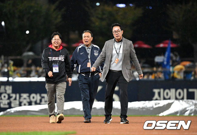 [OSEN=광주, 이대선 기자] 21일 광주 기아챔피언스필드에서 2024 신한 SOL뱅크 KBO 한국시리즈 1차전 KIA 타이거즈와 삼성 라이온즈의 경기가 열렸다.KIA는 네일, 삼성은 원태인을 선발 투수로 내세웠다.경기장에 비가 내리가 임채섭, 김시진 경기감독관이 그라운드를 살피고 있다. 2024.10.21 / sunday@osen.co.kr