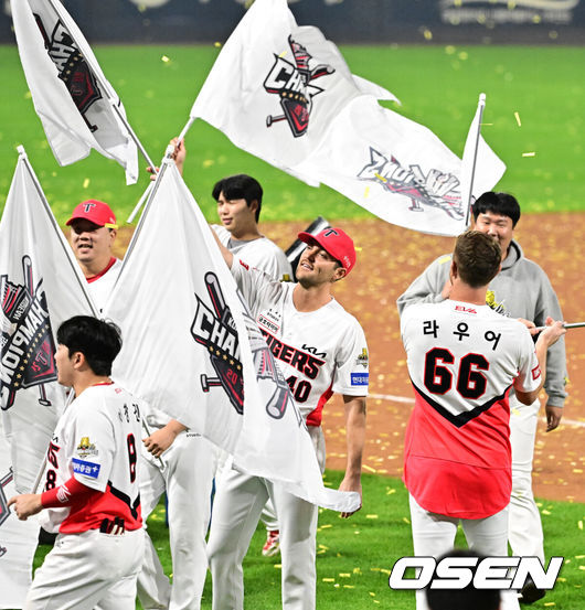 [OSEN=광주, 지형준 기자] KIA 타이거즈가 불패의 12번째 우승을 달성했다. KIA는 28일 광주-기아 챔피언스필드에서 열린 삼성 라이온즈와의 2024 신한은행 SOL 뱅크 KBO 한국시리즈 5차전에서 접전끝에 7-5로 승리했다. 선발 양현종이 홈런 3개를 맞고 5실점했으나 두터운 불펜이 무실점으로 막고 추격전을 벌였다. 최형우의 홈런포함 2타점, 김태군의 역전타와 박찬호의 귀중한 쐐기타가 나왔다. 시리즈 4승1패로 우승의 감격을 누렸다. KIA 네일, 라우어가 우승 깃발을 흔들며 기뻐하고 있다. 2024.10.28 / jpnews@osen.co.kr