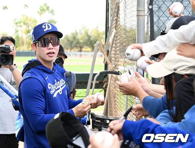 [OSEN=애리조나(미국), 이대선 기자] 17일(한국시간) 미국 애리조나주 글렌데일 캐멀백 랜치에서 2025 메이저리그 LA 다저스의 스프링캠프가 진행됐다.김혜성은 다저스와 최대 3+2년 2200만 달러(약 320억원) 계약에 합의하며 메이저리그 진출에 성공했다.LA 다저스 김혜성이 이동 중 팬들에게 사인을 해주고 있다. 2025.02.17 / sunday@osen.co.kr