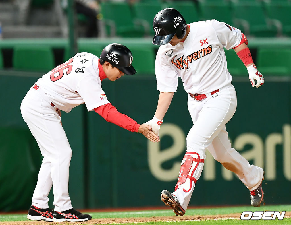 4회말 1사 만루 SK 최정이 만루 홈런을 날린 뒤 정수성 코치와 하이파이브를 하고 있다. /pjmpp@osen.co.kr