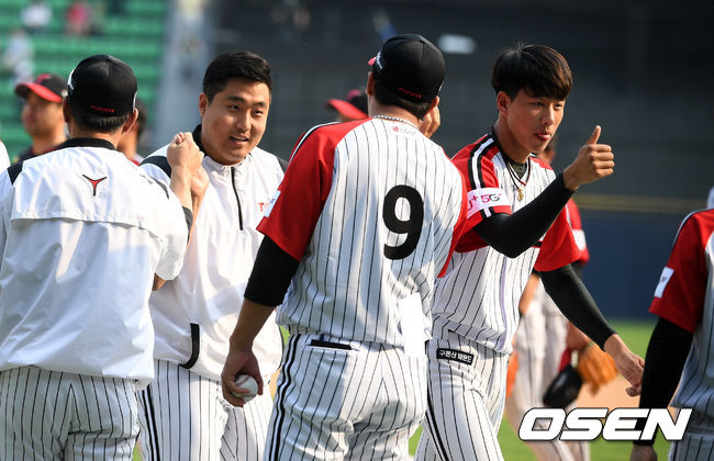 데뷔 첫 승을 거둔 LG 이우찬(사진 왼쪽)이 코칭스태프와 하이파이브를 하고 있다./jpnews@osen.co.kr