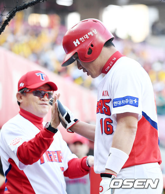 KIA 터커의 중견수 앞 선취 1타점 적시타때 홈을 밟은 김주찬이 덕아웃에서 박흥식 감독 대행과 하이파이브를 하고 있다./rumi@osen.co.kr