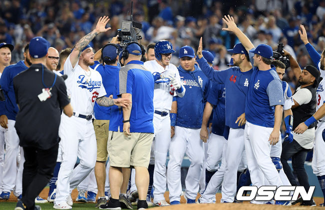 LA 다저스가 올스타 휴식기 전 마지막 홈 6연전 첫 경기를 짜릿한 끝내기로 장식했다.  다저스는 3일(이하 한국시간) 미국 캘리포니아주 로스앤젤레스 다저 스타디움에서 열린 애리조나 다이아몬드백스와의 경기에서 9회말 2사 후 코디 벨린저의 끝내기로 5-4로 승리했다. 다저스는 시즌 58승29패를 기록했고, 애리조나는 43승44패가 됐다.  9회말 2사 만루 상황 LA다저스 코디 벨린저가 끝내기 밀어내기 볼넷으로 역전 성공, 팀원들과 기쁨을 나누고 있다. / eastsea@osen.co.kr