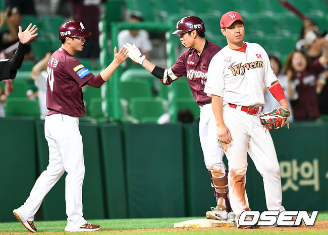 7회초 2사 만루 키움 이정후가 싹쓸이 3루타를 날린 뒤 조재영 코치와 하이파이브를 하고 있다. /pjmpp@osen.co.kr