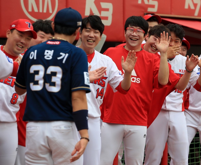 KIA 선수들이 활짝 웃으면서 NC 이명기와 하이파이브를 하고 있다./KIA타이거즈 제공.
