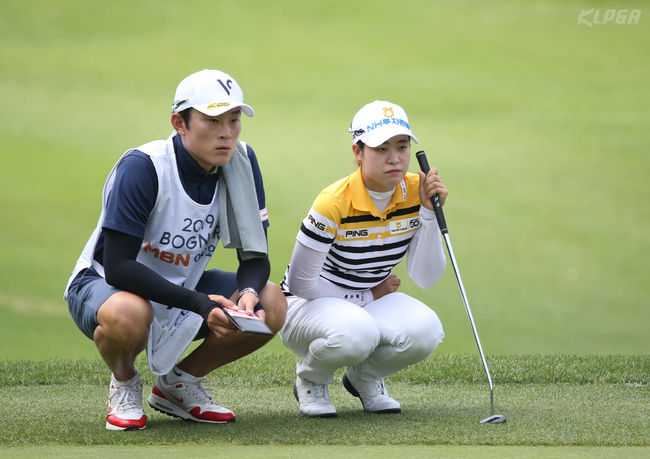 박민지가 3번홀에서 캐디와 나란히 앉아 그린을 살피고 있다. /KLPGA 제공.
