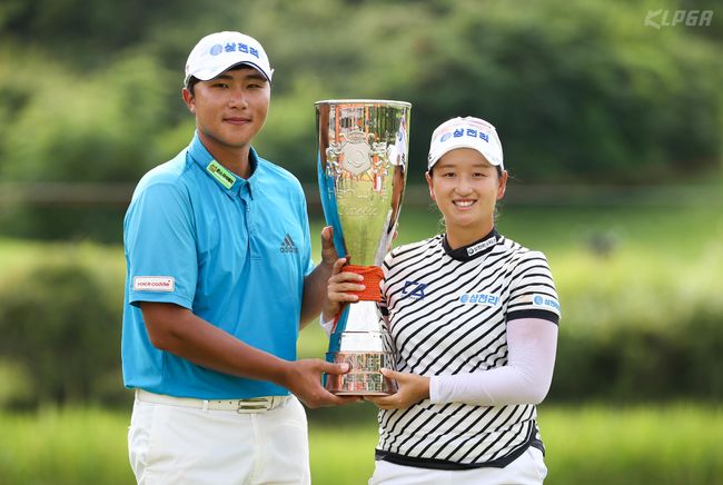 박채윤이 캐디와 함께 트로피를 들어 보이고 있다.