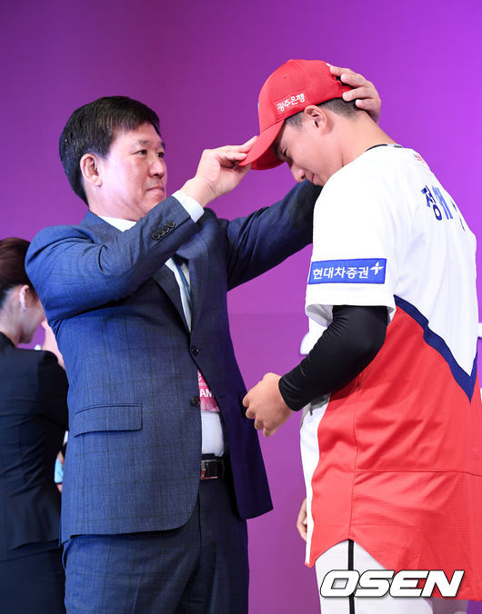 2020 KBO 신인 드래프트가 26일 오후 서울 웨스틴조선호텔 그랜드볼룸에서 열렸다.  KBO 신인 드래프트는 1라운드부터 10라운드까지 진행되며 지명 순서는 2018년 팀순위의 역순인 NC-KT-LG-롯데-삼성-KIA-키움-한화-두산-SK 순으로 실시됐다.   1차 지명된 KIA타이거즈 정해영(광주제일고)가 조계현 단장에 모자와 유니폼을 건네 받고 있다. /jpnews@osen.co.kr
