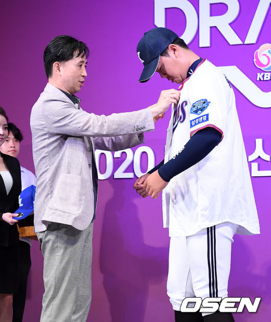 2020 KBO 신인 드래프트가 26일 오후 서울 웨스틴조선호텔 그랜드볼룸에서 열렸다.KBO 신인 드래프트는 1라운드부터 10라운드까지 진행되며 지명 순서는 2018년 팀순위의 역순인 NC-KT-LG-롯데-삼성-KIA-키움-한화-두산-SK 순으로 실시됐다. 1차 지명된 삼성라이온즈 황동재(경북고)가 홍준학 단장에 유니폼을 건네 받고 있다. /jpnews@osen.co.kr