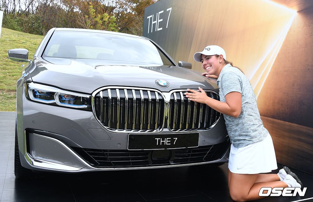 생애 첫 홀인원으로 BMW 7시리즈를 부상으로 챙긴 크리스틴 길먼이 차에 포옹하는 포즈를 취하며 기뻐하고 있다.