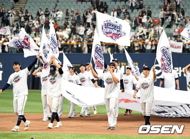 우승을 차지한 두산 선수들이 우승기를 흔들며 관중석을 향해 인사를 하고 있다. /sunday@osen.co.kr