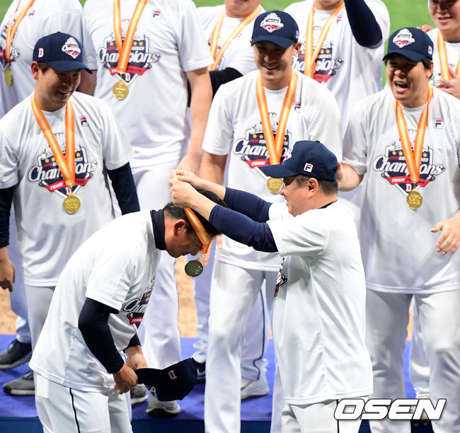 두산 김태형 감독이 정재훈 코치에게 자신의 메달을 건네고 있다. /jpnews@osen.co.kr