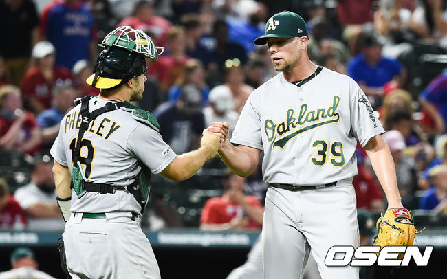 9회말 1사 만루 위기를 넘기며 승리를 지킨 오클랜드 트레이넨 마무리 투수와 페글리 포수가 하이파이브를 하고 있다. /  soul1014@osen.co.kr