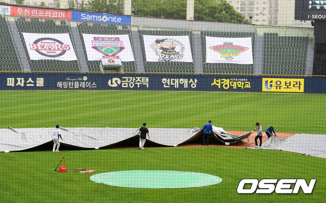 경기를 앞두고 다시 비가 내리자 그라운드에 방수포를 깔고 있다. /jpnews@osen.co.kr