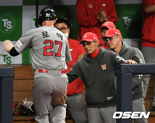 7회초 2사 1, 2루 상황 SK 남태혁의 달아나는 1타점 적시타 때 홈을 밟은 로맥이 염경엽 감독과 인사를 나누고 있다. / dreamer@osen.co.kr