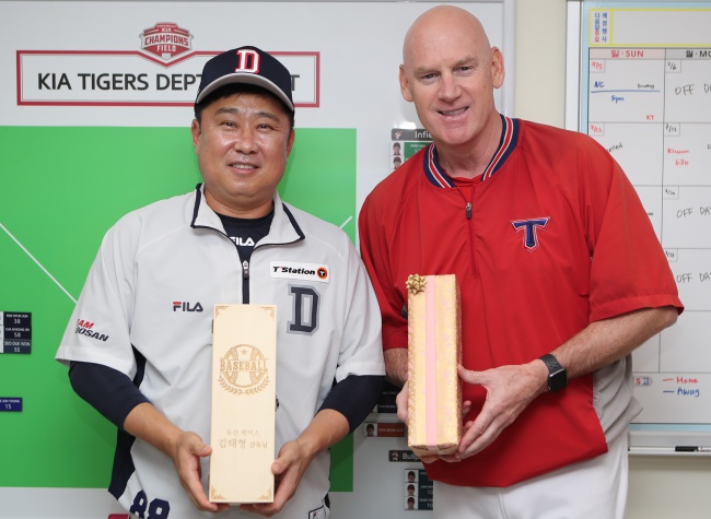 김태형 감독과 맷 윌리엄스 감독이 선물을 교환하고 활짝 웃고 있다./KIA 타이거즈 제공