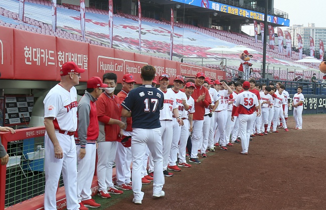 두산으로 이적한 홍건희가 17일 챔피언스필드를 찾아 옛 동료들과 석별의 하이파이브를 하고 있다./KIA 타이거즈제공