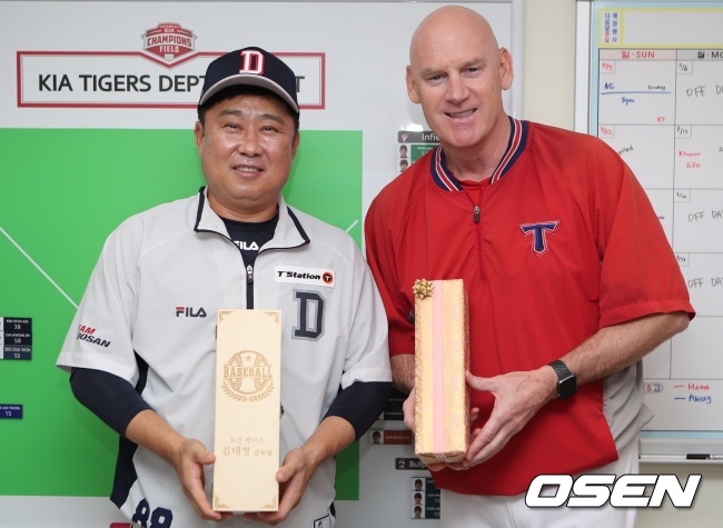 지난 17일 김태형 두산 감독과 맷 윌리엄스 KIA 타이거즈 감독이 선물을 주고 받고 포즈를 취했다./KIA 타이거즈 제공.