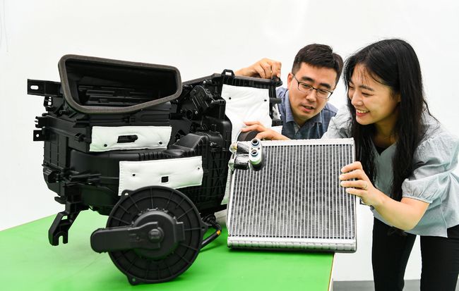 공조설계팀 연구원들이 애프터 블로우 기술의 핵심 부품인 에바포레이터와 블로워 모터를 살피고 있다. 