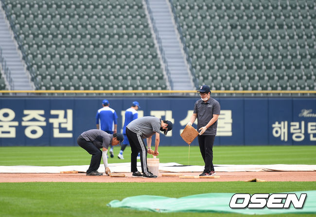 5일 서울 잠실야구장에서 ‘2020 신한은행 SOL KBO리그’ 두산 베어스와 삼성 라이온즈의 경기가 열린다.잠실 관계자들이 스펀지 등으로 물을 빼내고 있다./ksl0919@osen.co.kr