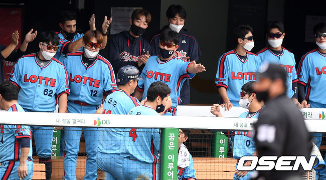 롯데 이대호가 정훈의 적시타 때 홈으로 쇄도해 득점을 올리고 더그아웃에서 동료들의 축하를 받고  있다. /sunday@osen.co.kr