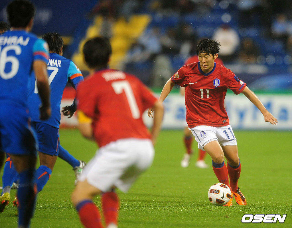 손흥민이 드리블을 하고 있다. 당시 주장 박지성의 뒷모습.