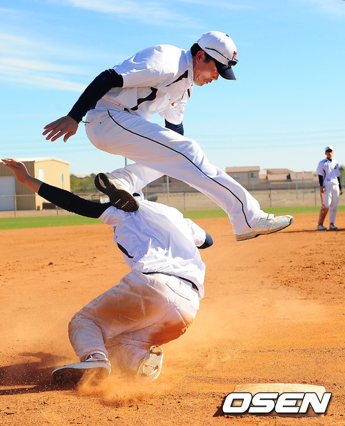 두산 스프링캠프에서 두산 정수빈이 슬라이딩을 할때 김민호 코치가 점프하며 피하는 훈련을 하고 있다.