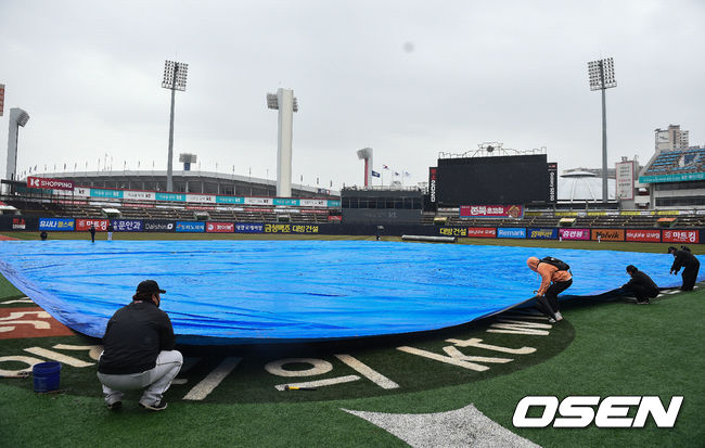 경기 관계자들이 방수포를 덮고 있다. / soul1014@osen.co.kr