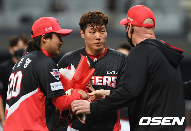 프로 데뷔 첫 승을 거둔 KIA 김재열과 첫 세이브 이준영에게 윌리엄스 감독이 축하 꽃다발을 건네고 있다. / dreamer@osen.co.kr