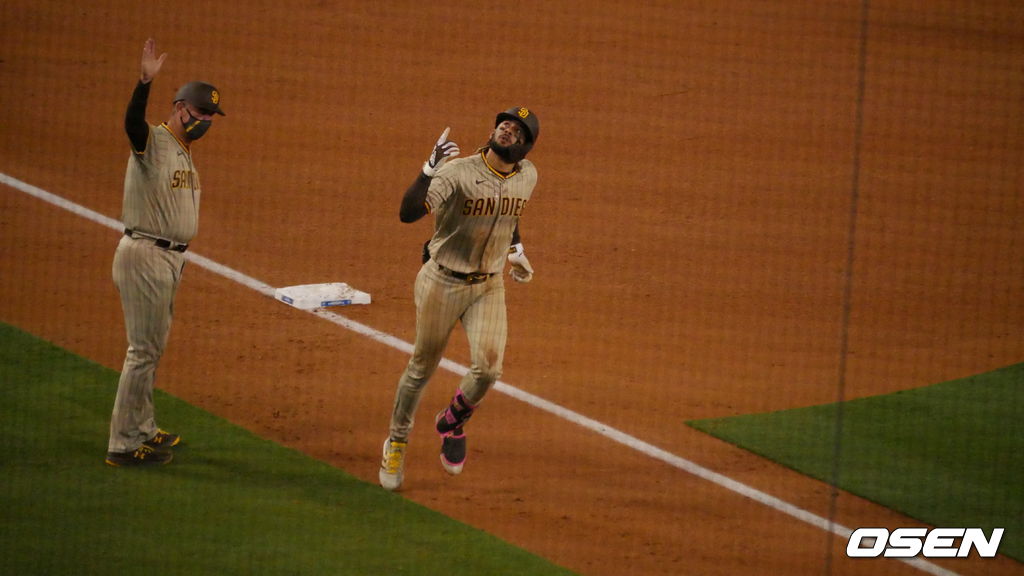 [OSEN=LA, 이사부 통신원] 샌디에이고의 페르난도 타티스 주니어(오른쪽)가 24일(한국시간) 다저스타디움에서 벌어진 LA 다저스와의 경기 3회서 솔로 홈런을 날린 뒤 3루를 돌면서 세리머니를 펼치고 있다. /lsboo@osen.co.kr