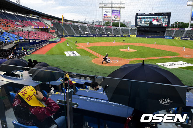 경기 시작과 함께 비가 내리자 팬들이 우산과 수건으로 비를 피하고 있다. /jpnews@osen.co.kr