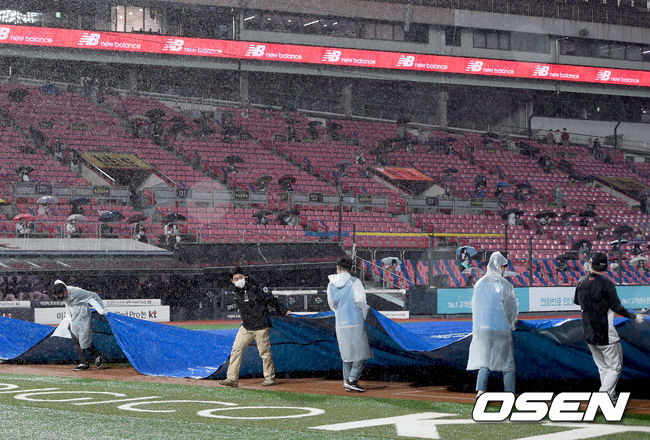 20일 오후 경기도 수원시 수원kt위즈파크에서 ‘2021 신한은행 SOL KBO 리그’ KT 위즈와 두산 베어스의 경기가 열렸다.3회초 무사 만루 갑자기 내리는 비에 경기가 중단되고 있다. 그라운드에 방수포 덮는 관계자들./ksl0919@osen.co.kr